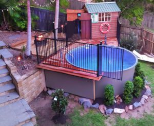 Clipper Swimming pool with a wooden deck and landscaped surroundings